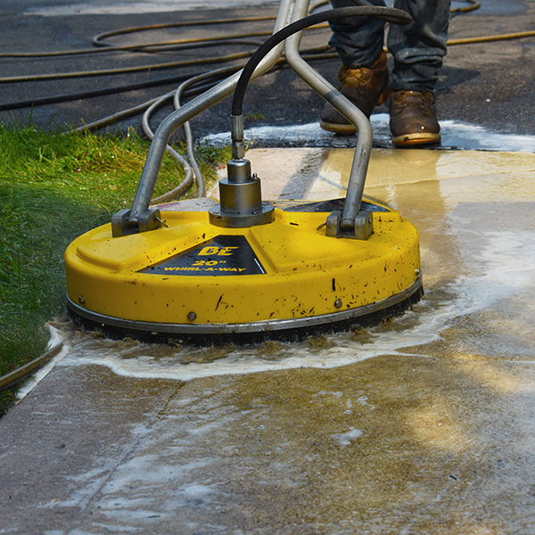 “Professional driveway cleaning service in Lakewood, CO by JJ Power Washing – removing dirt and oil stains using high-pressure washer.”